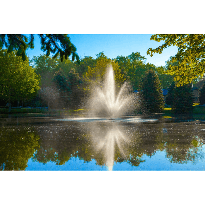 Cambridge Pond Fountain by Scott Aerator creating a mirrored water display in a wooded pond