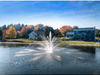 Cambridge display pond fountain operating in a residential lake with homes behind it