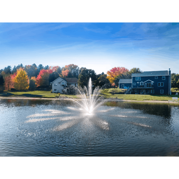 Cambridge display pond fountain operating in a residential lake with homes behind it
