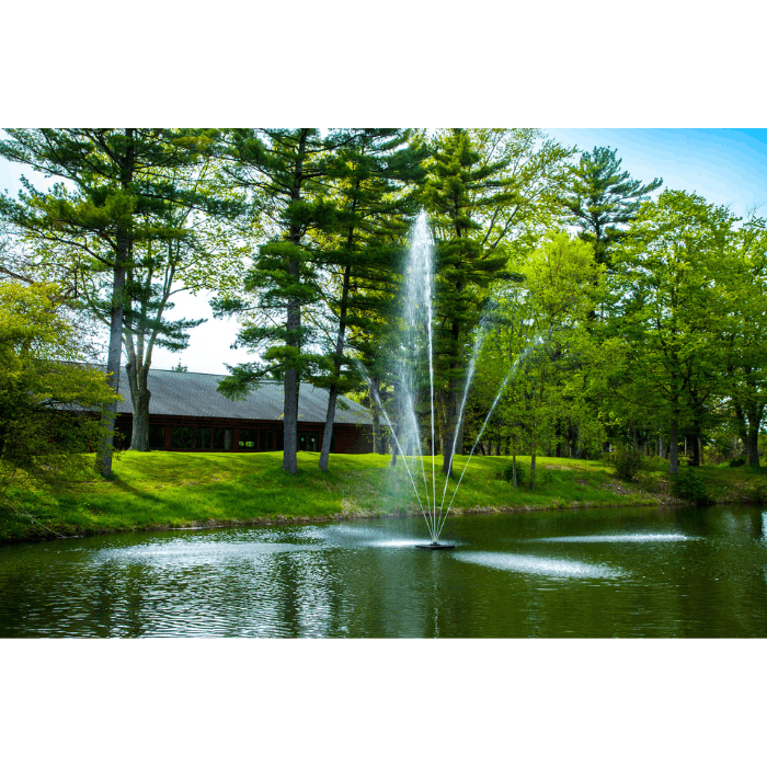 Clover Pond Fountain by Scott Aerator in a landscaped pond near a building