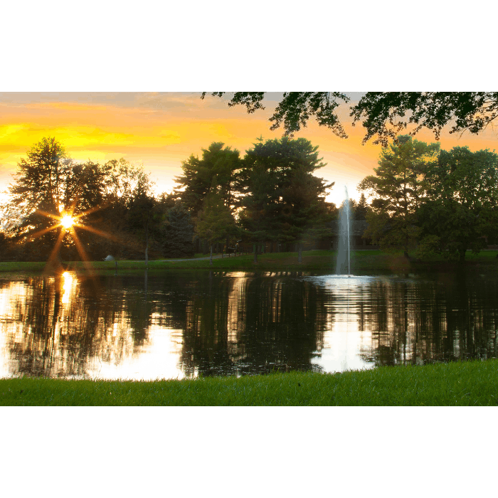 Gusher Pond Fountain by Scott Aerator glowing against a golden evening sky