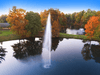 Gusher Pond Fountain by Scott Aerator producing a tall vertical plume over a fall landscape