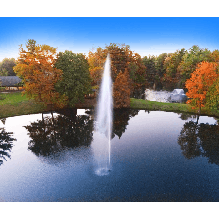Gusher Pond Fountain by Scott Aerator producing a tall vertical plume over a fall landscape