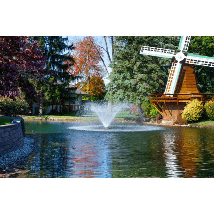 Scott Aerator DA-20 display aerator installed in a residential pond near decorative windmill landscaping