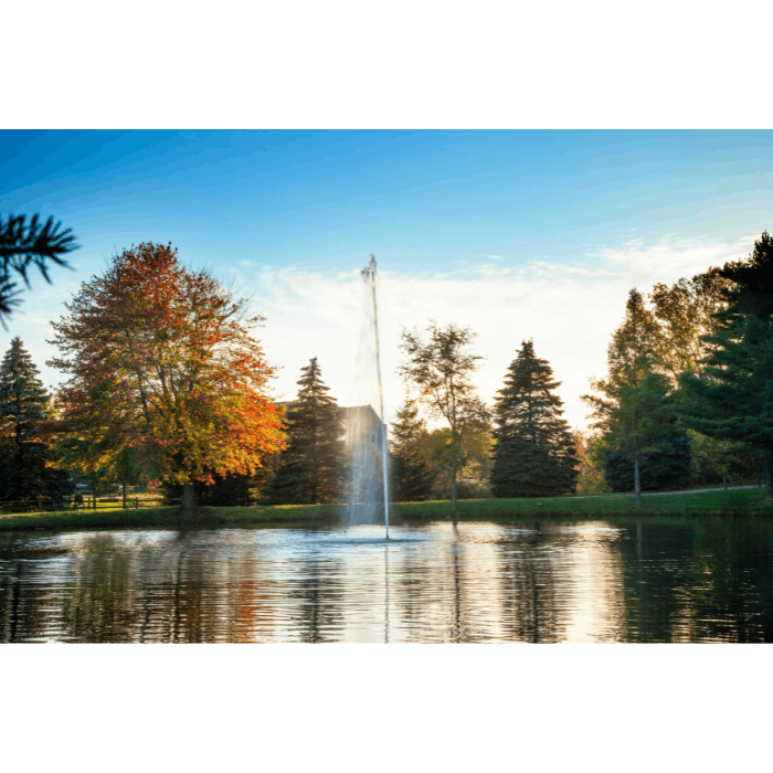 Scott Aerator Gusher fountain operating in a pond with autumn trees and soft evening light