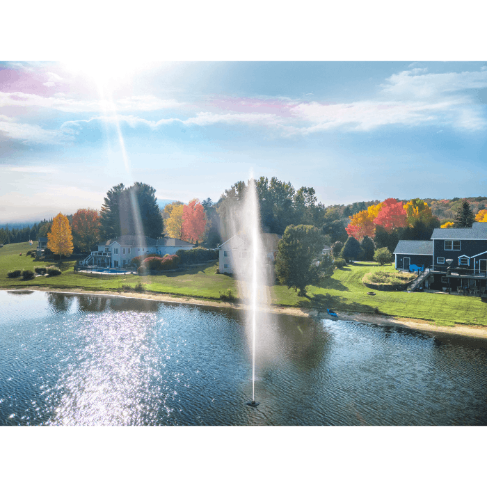 Scott Aerator Gusher fountain spraying in a residential lake with shoreline homes in view