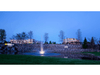 Skyward Pond Fountain by Scott Aerator illuminated in a landscaped commercial pond at dusk