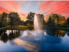 Skyward fountain by Scott Aerator spraying beneath a dramatic pink and orange sunset