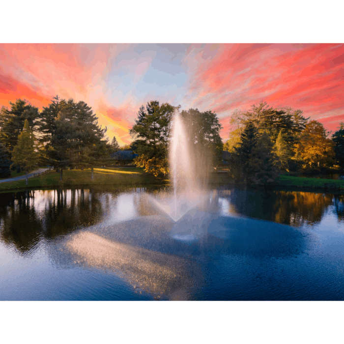 Skyward fountain by Scott Aerator spraying beneath a dramatic pink and orange sunset
