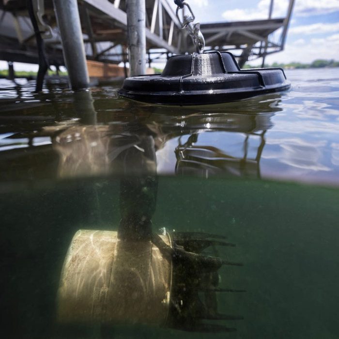AquatiClear system installed beneath a dock with submerged motor unit visible below the water surface