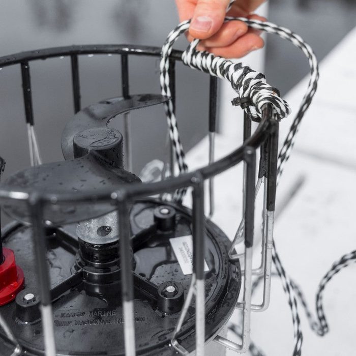 Close-up of Kasco De-Icer showing protective cage housing and power cord connection during winter use