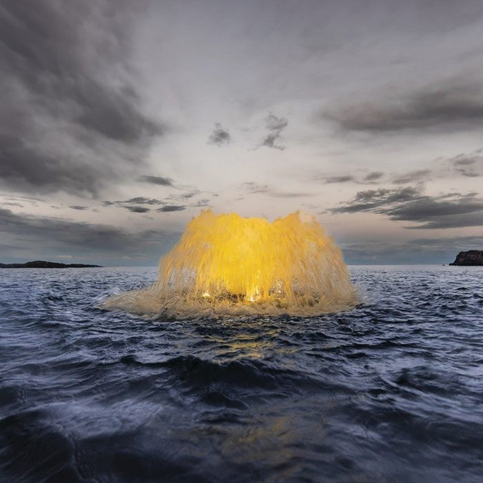 Kasco Aerator producing an illuminated spray pattern in open water during evening operation