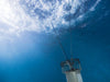Kasco De-Icer operating underwater beneath ice surface with visible water circulation and suspension cable