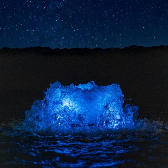 Kasco RGB LED creating a blue illuminated bubbling water feature under a night sky