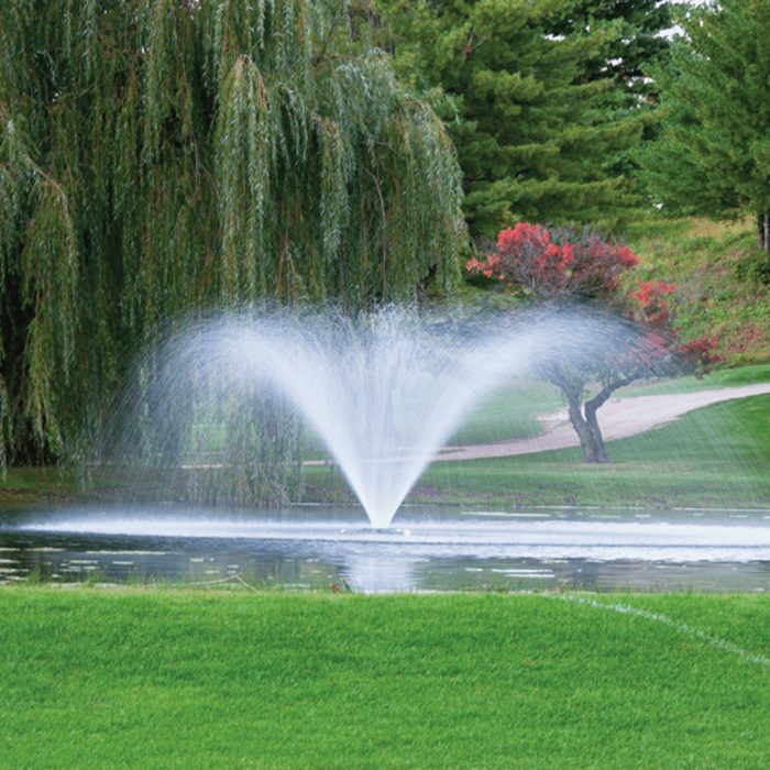 Kasco VFX Series with the V-spray pattern in front of green trees and grass