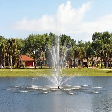 Vertex TriTier Floating Fountain Series On Water with Trees and Houses at the Background