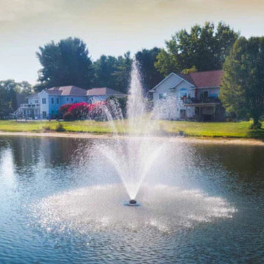 Scott Aerator Solar Amherst Fountain in a lake with houses and trees in the background