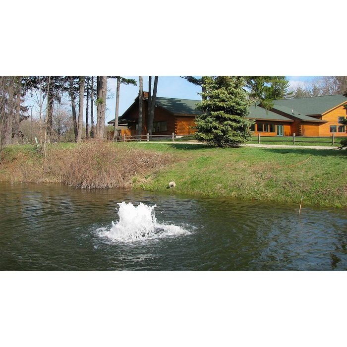 Scott Aerator Solar Boilermaker on a wooded pond with a cabin in the background