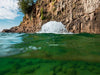 Surface Aerator churning water near rocky cliff shoreline with visible underwater clarity