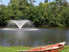 VFX fountain producing a circular spray on a lake with a canoe on the grassy shoreline